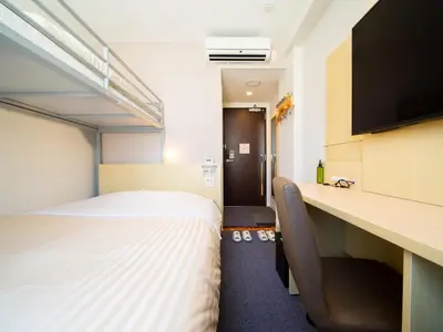 a hotel room with a bed and a desk at Super Hotel Tokyo Shiba in Tokyo