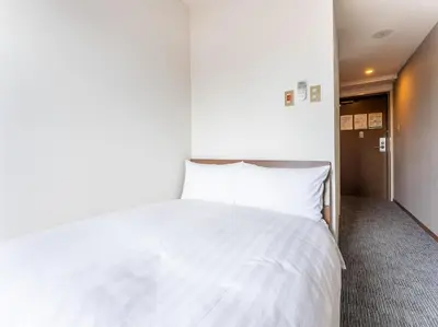a bedroom with a white bed and a hallway at Tabist Urban Stays Asakusa in Tokyo
