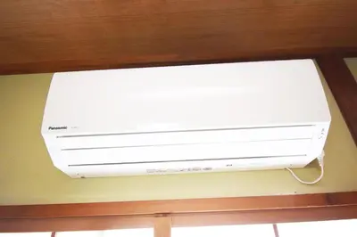 a white air conditioner is hanging on a wall at Oasis Minamiyukigaya in Tokyo