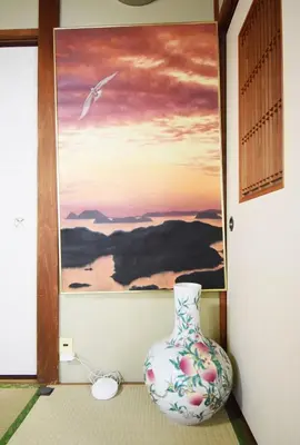 a vase sitting on the floor in front of a painting at Oasis Minamiyukigaya in Tokyo