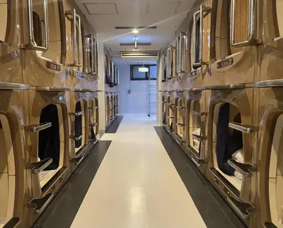 a row of silos in a building with a long aisle at Capsule Inn Kinshicho in Tokyo