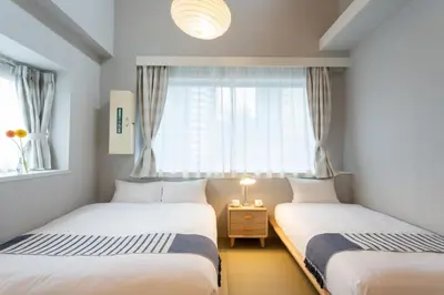 two beds in a room with a window at Playsis East Tokyo in Tokyo