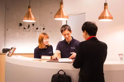 two men and a woman standing at a counter at Playsis East Tokyo in Tokyo