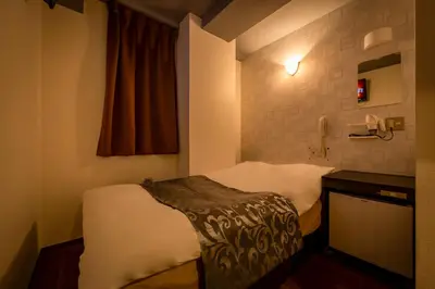 a hotel room with a bed and a telephone at Hotel Peace (Adult Only) in Tokyo