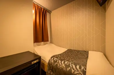 a small room with a bed and a table at Hotel Peace (Adult Only) in Tokyo