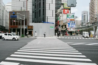 a crosswalk on a city street with cars and buildings at Hotel Peace (Adult Only) in Tokyo