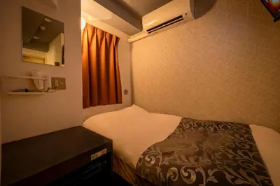 a small room with a bed and a window at Hotel Peace (Adult Only) in Tokyo