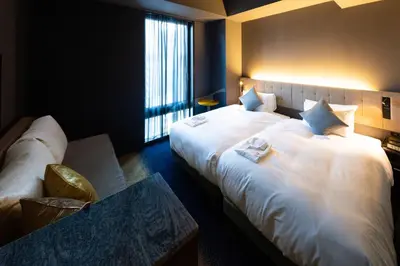 a hotel room with two beds and a window at The Royal Park Canvas - Ginza 8 in Tokyo