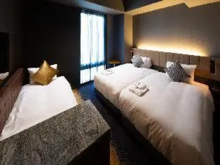 a bedroom with two beds with white sheets and a window at The Royal Park Canvas - Ginza 8 in Tokyo