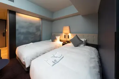 a hotel room with two beds and a window at The Royal Park Canvas - Ginza 8 in Tokyo