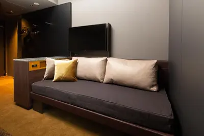 a couch with pillows on it in a room at The Royal Park Canvas - Ginza 8 in Tokyo