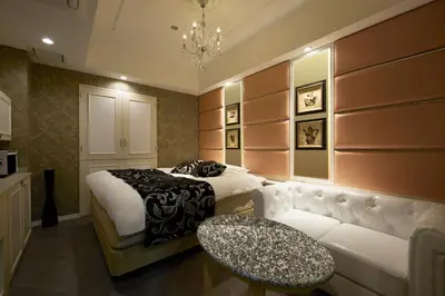 a bedroom with a bed and a couch and a table at HOTEL EXE (Adult Only) in Tokyo