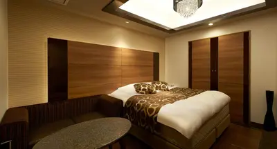 a bedroom with a bed and a bench in it at HOTEL EXE (Adult Only) in Tokyo