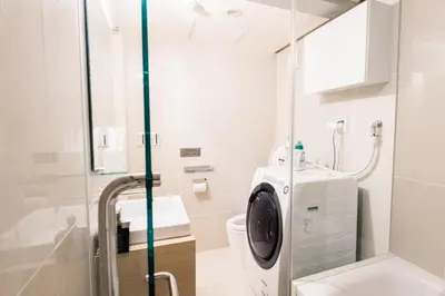 a bathroom with a toilet and a glass shower stall at SPATIUM GINZA in Tokyo