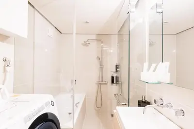 a white bathroom with a shower and a sink at SPATIUM GINZA in Tokyo
