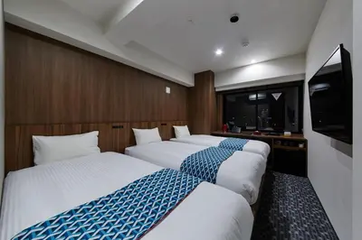 a room with two beds and a flat screen tv at HOTEL AMANEK Asakusa Ekimae in Tokyo