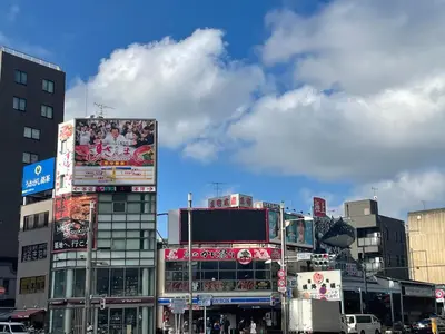 a busy city street with tall buildings and signs at HOTEL AMANEK Asakusa Ekimae in Tokyo