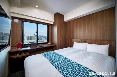 a bedroom with a bed and a desk with a window at HOTEL AMANEK Asakusa Ekimae in Tokyo