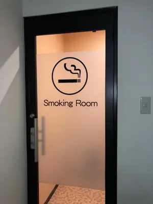 a door with a smoking room sign on it at Hatoya Hotel in Tokyo