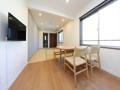 a dining room with a table and chairs and a flat screen tv at COTO Tokyo Shibuya 4 in Tokyo