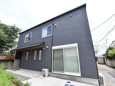 a black house with white windows on a street at COTO Tokyo Shibuya 4 in Tokyo