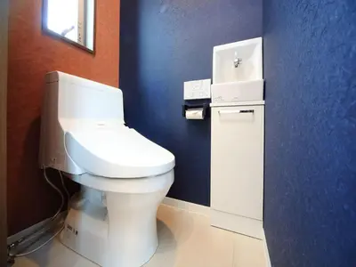 a bathroom with a white toilet in a blue wall at COTO Tokyo Shibuya 4 in Tokyo