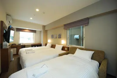 a hotel room with two beds and a window at Sotetsu Fresa Inn Hamamatsucho-Daimon in Tokyo