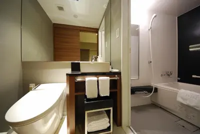 a bathroom with a toilet and a sink and a tub at Sotetsu Fresa Inn Hamamatsucho-Daimon in Tokyo