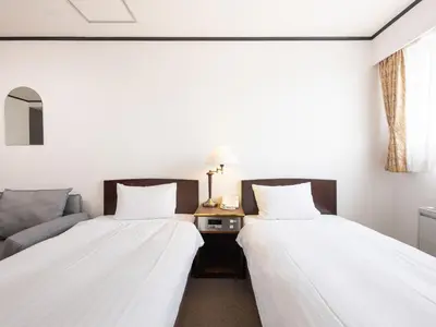 two beds sitting next to each other in a room at Tabist Hotel New Washington Shibuya in Tokyo