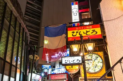 a group of signs on a city street at night at Tabist Hotel New Washington Shibuya in Tokyo