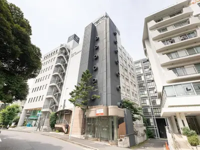 a building with a tree in front of it at Tabist Hotel New Washington Shibuya in Tokyo