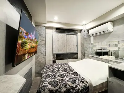 a bedroom with a bed and a painting on the wall at Hotel Rocks in Tokyo