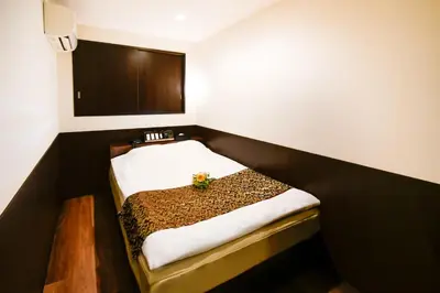 a small room with a bed in the corner at Ikebukuro Central Hotel in Tokyo