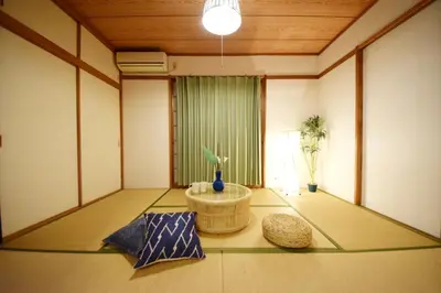 a room with a round table in the middle of a room at The Nest Ikebukuro House in Tokyo