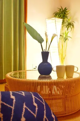 a table with a blue vase and two cups on it at The Nest Ikebukuro House in Tokyo