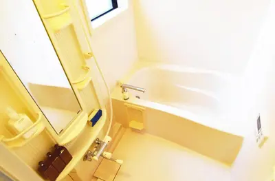 a small bathroom with a tub and a sink at The Nest Ikebukuro House in Tokyo