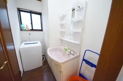 a white bathroom with a sink and a mirror at The Nest Ikebukuro House in Tokyo