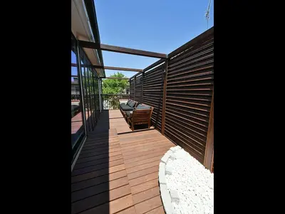 a wooden deck with a bench on the side of a house at KandoStay \u6d45\u8349EAST\u30c6\u30e9\u30b9 in Tokyo