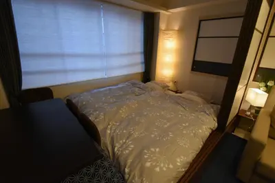 a small bedroom with a bed and a window at KandoStay EAST TORANOMON in Tokyo
