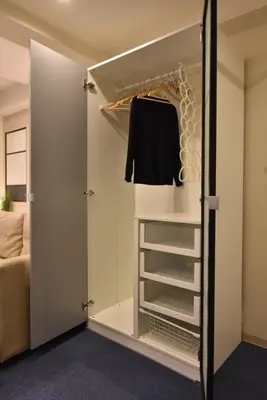 a walk in closet with a black shirt in it at KandoStay EAST TORANOMON in Tokyo