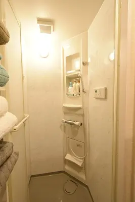 a small bathroom with a white refrigerator and shelves at KandoStay EAST TORANOMON in Tokyo