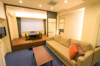 a living room with a couch and a table at KandoStay EAST TORANOMON in Tokyo