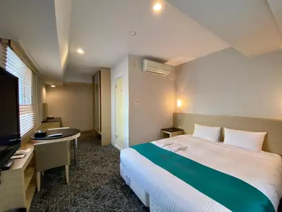 a hotel room with a bed and a desk and a television at Sotetsu Fresa Inn Tokyo-Kyobashi in Tokyo