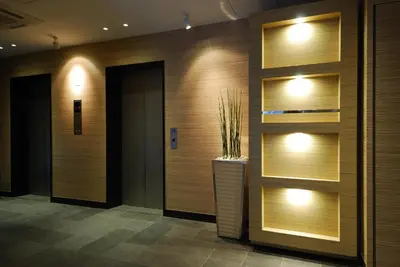 a lobby with wooden walls and a vase with a plant at Sotetsu Fresa Inn Tokyo-Kyobashi in Tokyo