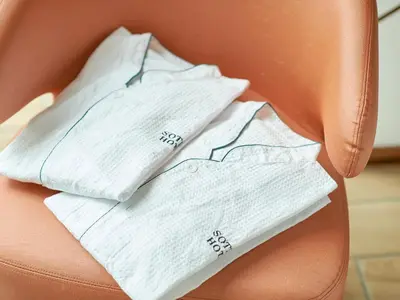 a pile of white towels sitting on a orange chair at Sotetsu Fresa Inn Tokyo-Kyobashi in Tokyo