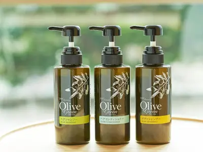 three bottles of olive cosmetics sitting on a table at Sotetsu Fresa Inn Tokyo-Kyobashi in Tokyo