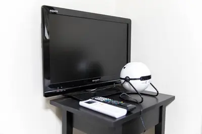 a computer monitor and a helmet sitting on a table at Tokyo Aoto House in Tokyo