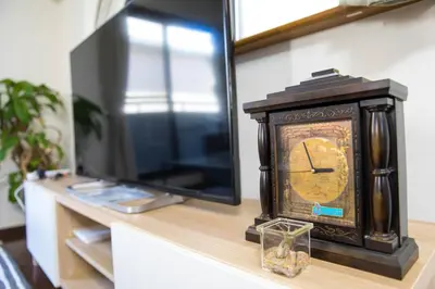 a clock sitting on a table next to a tv at Tokyo Aoto House in Tokyo