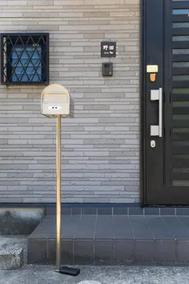 a mailbox on the sidewalk in front of a building at Tokyo Aoto House in Tokyo