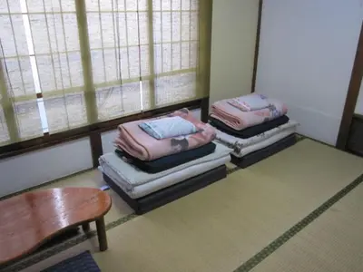 a room with three stacks of mattresses on the floor at Taito Ryokan in Tokyo